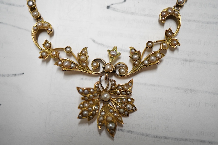 An Edwardian 9ct and split pearl cluster set drop pendant necklace, overall 44cm, gross weight 8 grams.